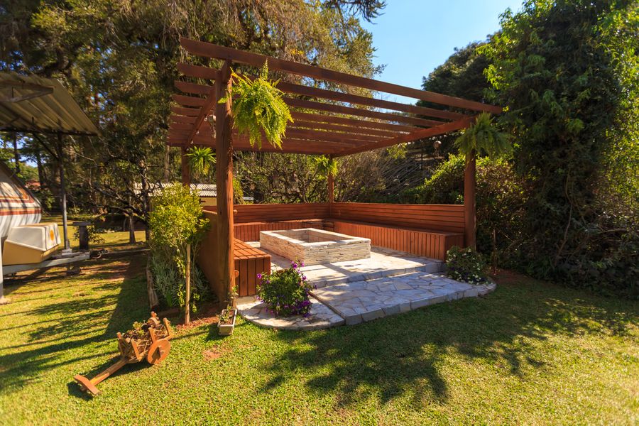 Wooden pergola cabana with built-in bench seating on a patio