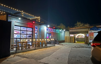 Stinson Yard gathering space lit by string lights at night
